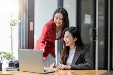 PCを見ながら相談している様子のイメージ